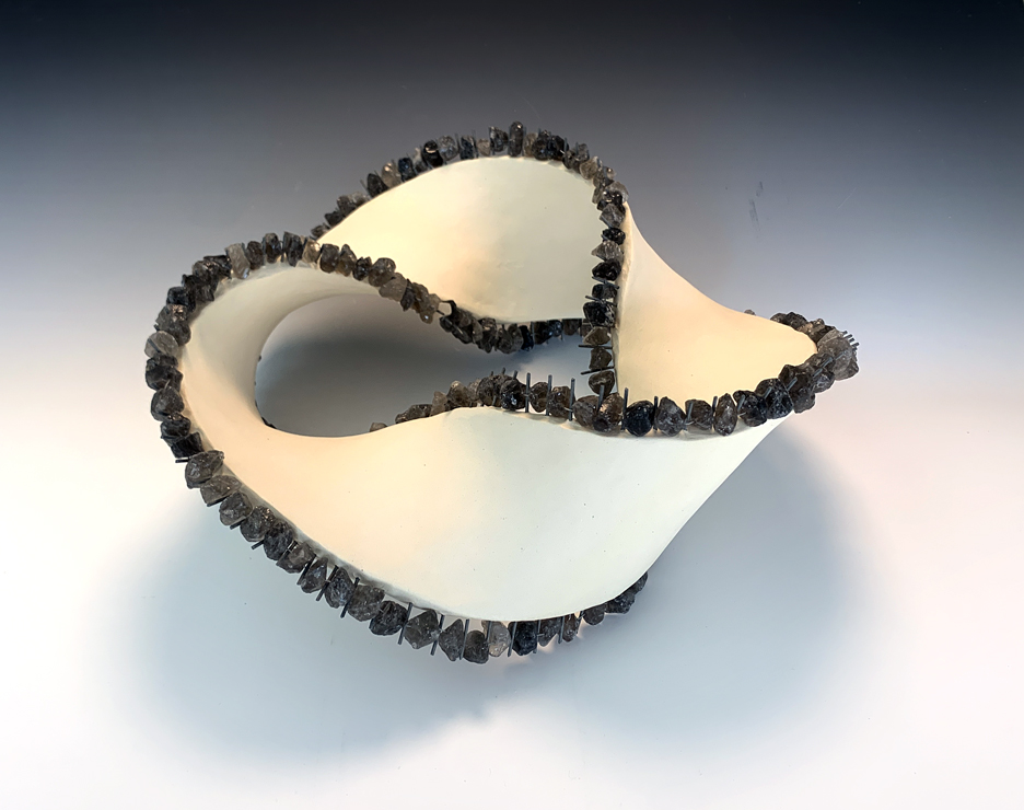 Ceramic sculpture of a Mobius band with quartz beads.